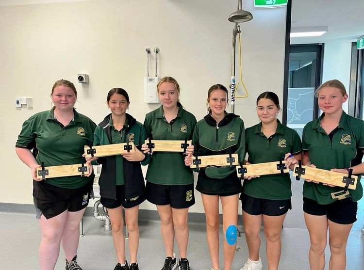 Photograph of students in Wee Waa High School uniform standing inside classroom with timber door hooks made in timber class