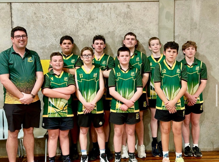 Photograph of students dressed in Wee Waa High School basketball uniform in front of concrete wall with teacher dressed in Wee Waa High School polo shirt