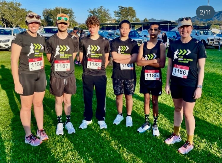 Photograph of Wee Waa High School students and staff standing on grassed area dressed in activewear at running festival