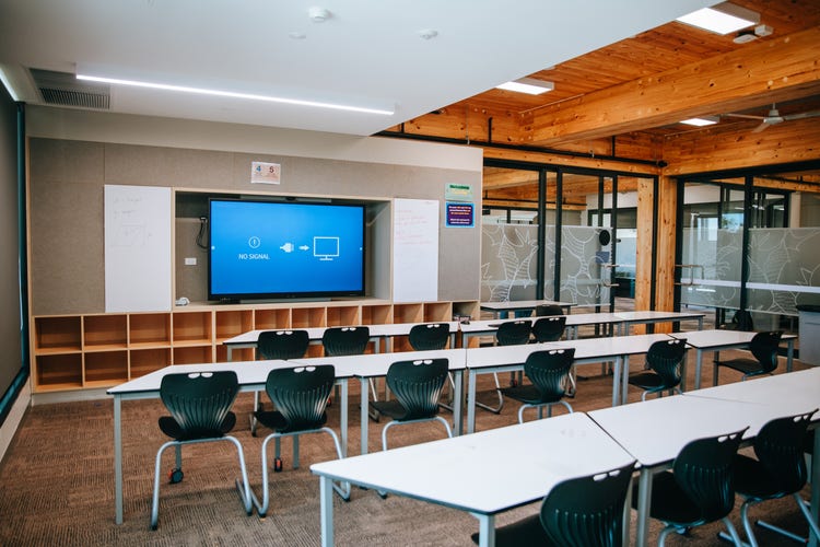 Photograph of Wee Waa High School learning hub classroom with desks, chairs, hight timber ceilings, and natural light