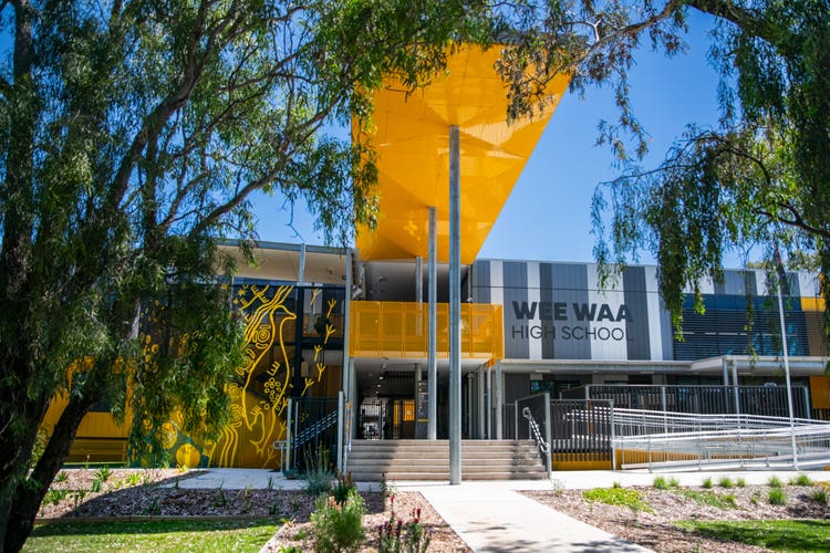 Photograph of Wee Waa High School building under blue sky surrounded by trees